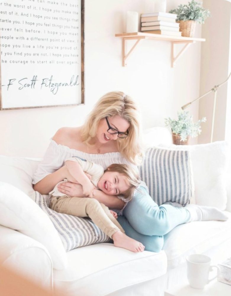 A mother laughing with her young son on the couch
